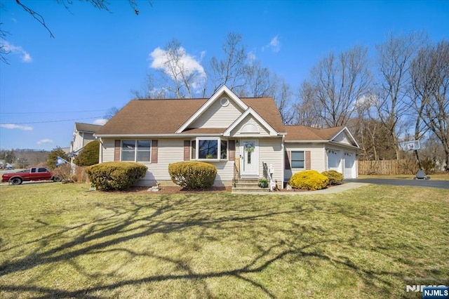 view of front of property with a garage, fence, a front lawn, and aphalt driveway