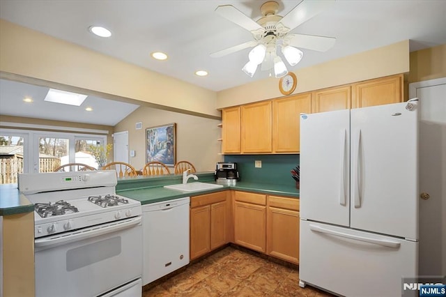 kitchen with lofted ceiling with skylight, recessed lighting, white appliances, and a sink