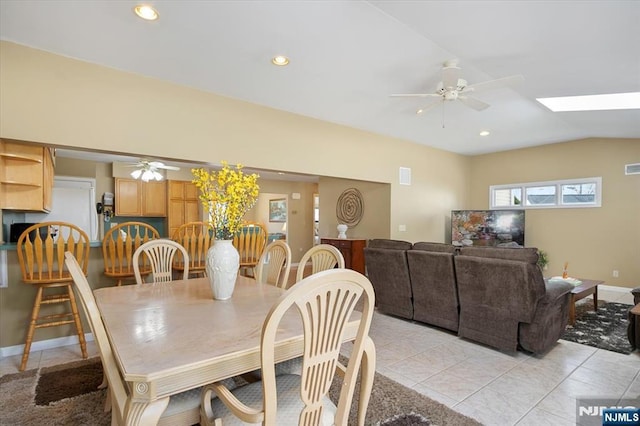 dining area with vaulted ceiling with skylight, ceiling fan, recessed lighting, and light tile patterned floors