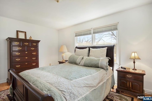 bedroom with baseboards and wood finished floors