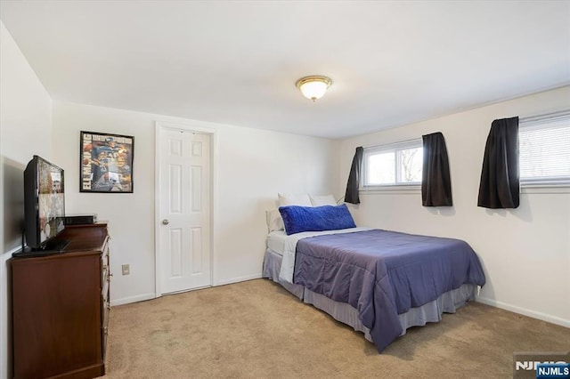 bedroom with light colored carpet and baseboards