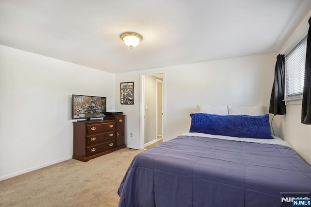 bedroom with light carpet and baseboards