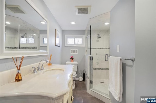 bathroom with visible vents, toilet, a shower stall, vanity, and tile patterned flooring