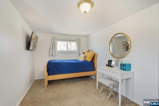 bedroom featuring light colored carpet and baseboards