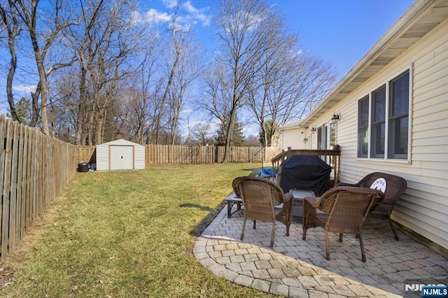 view of yard featuring a storage shed, a fenced backyard, a patio area, and an outdoor structure