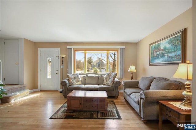 living area featuring light wood-style floors and baseboards