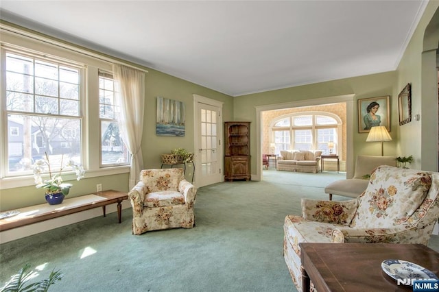 sitting room with plenty of natural light, ornamental molding, and carpet flooring