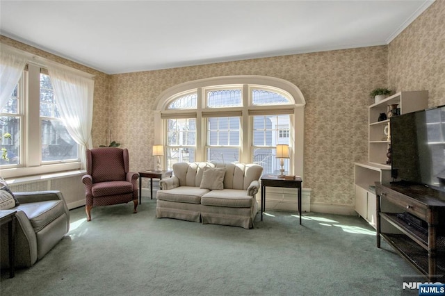 carpeted living area with plenty of natural light, wallpapered walls, crown molding, and baseboards