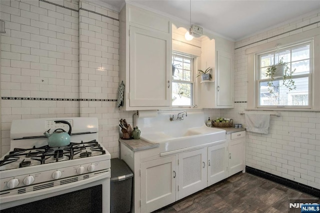 kitchen featuring ornamental molding, a sink, white gas range oven, white cabinets, and light countertops