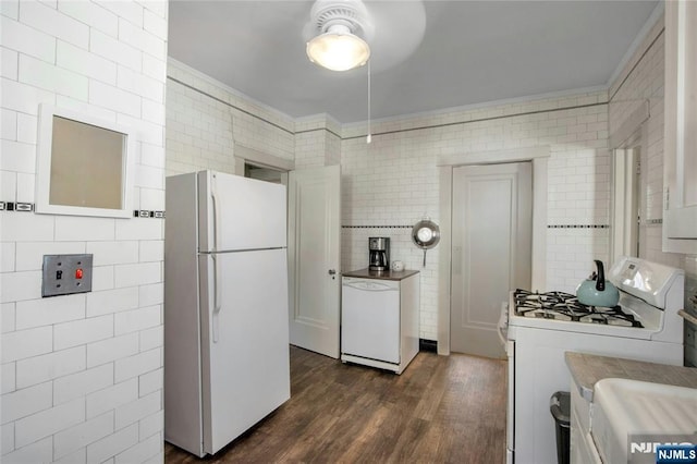 kitchen featuring dark wood finished floors, white appliances, tile walls, and crown molding