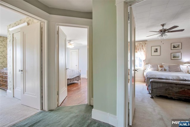 corridor with carpet flooring, wallpapered walls, and baseboards