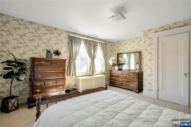 bedroom featuring light carpet, wallpapered walls, and baseboards