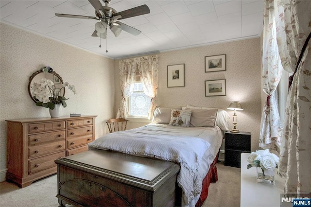 carpeted bedroom with a ceiling fan, crown molding, and wallpapered walls