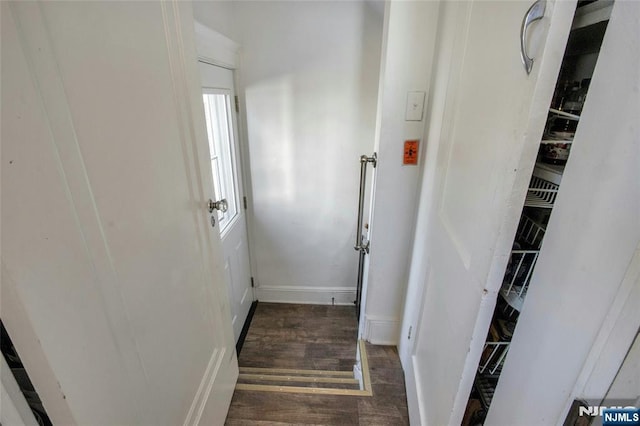 hallway featuring wood finished floors and baseboards