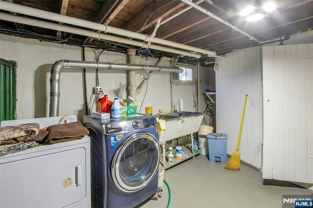 clothes washing area with laundry area, separate washer and dryer, and a sink