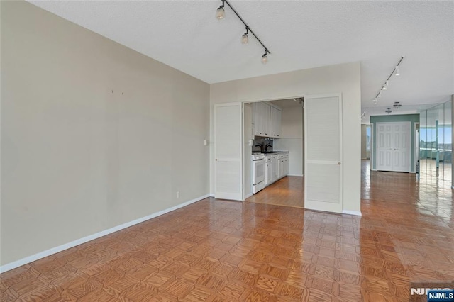 unfurnished living room featuring a sink, baseboards, and a textured ceiling