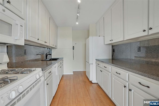 kitchen featuring light wood finished floors, decorative backsplash, white appliances, and white cabinetry