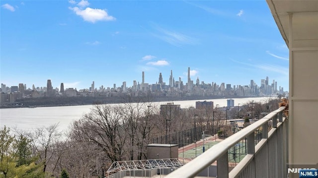 balcony featuring a water view and a city view