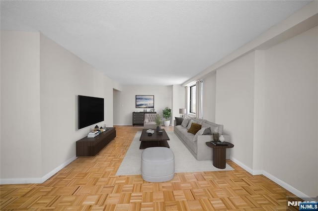 living area featuring a textured ceiling and baseboards