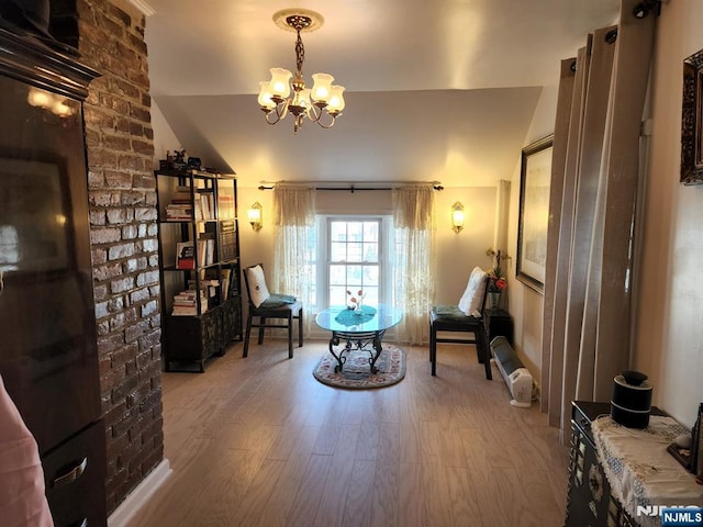 sitting room featuring a chandelier and wood finished floors