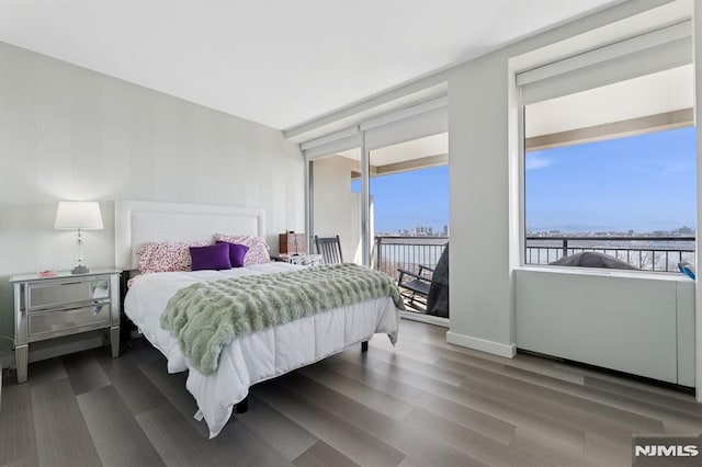 bedroom featuring access to exterior, wood finished floors, and baseboards