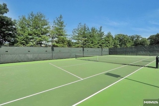 view of tennis court featuring fence