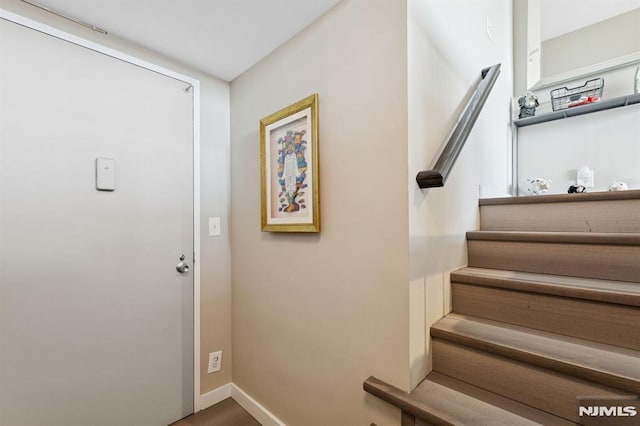 foyer featuring stairway and baseboards