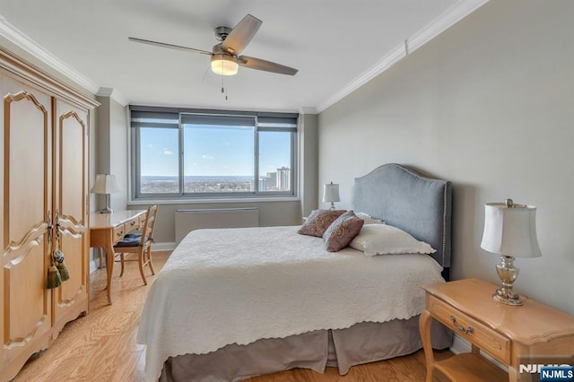 bedroom with crown molding, light wood-style flooring, and a ceiling fan