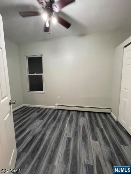 empty room featuring a ceiling fan, a baseboard radiator, baseboards, and wood finished floors