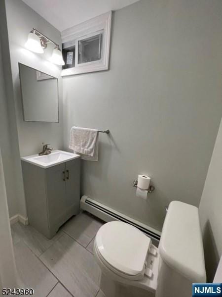 half bathroom featuring toilet, tile patterned flooring, and vanity