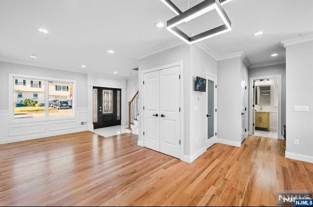 entrance foyer featuring stairs, light wood finished floors, recessed lighting, and crown molding