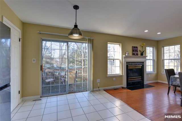 doorway with baseboards, visible vents, and a high end fireplace