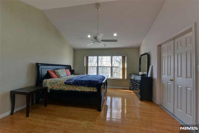 bedroom featuring baseboards, lofted ceiling, a ceiling fan, and light wood finished floors