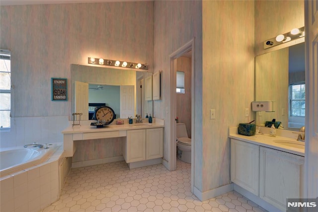 full bath with wallpapered walls, two vanities, and a sink