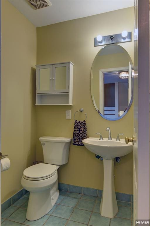 bathroom featuring tile patterned floors, toilet, baseboards, and visible vents