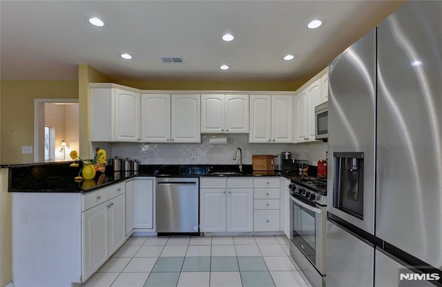 kitchen with visible vents, a sink, white cabinetry, stainless steel appliances, and light tile patterned flooring