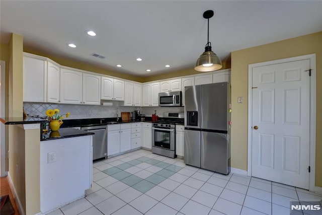 kitchen featuring dark countertops, visible vents, tasteful backsplash, appliances with stainless steel finishes, and white cabinets