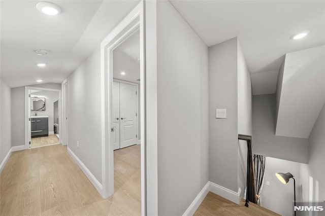 hall with recessed lighting, light wood-style floors, and baseboards