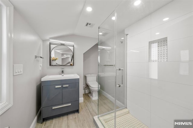 bathroom with visible vents, a shower stall, toilet, vaulted ceiling, and vanity