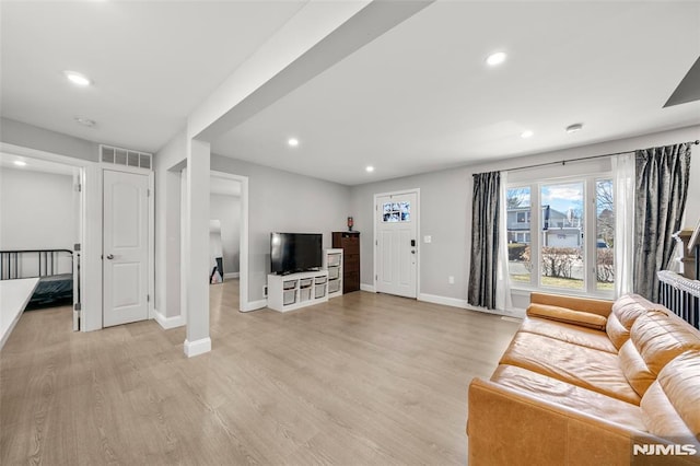 living room featuring light wood-style flooring, recessed lighting, visible vents, and baseboards