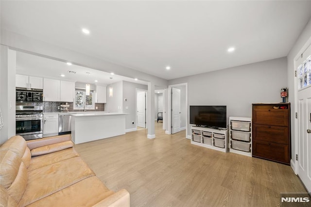 living area with visible vents, light wood-style flooring, recessed lighting, and baseboards