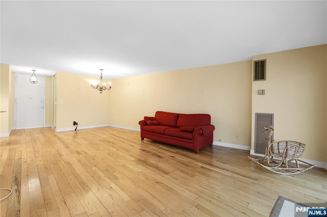 sitting room with a chandelier, baseboards, visible vents, and light wood finished floors