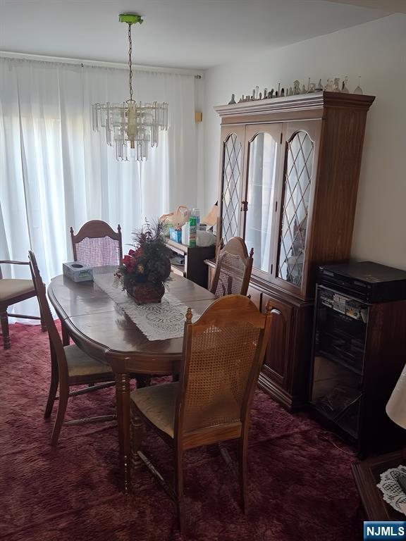 dining area with carpet floors and a notable chandelier