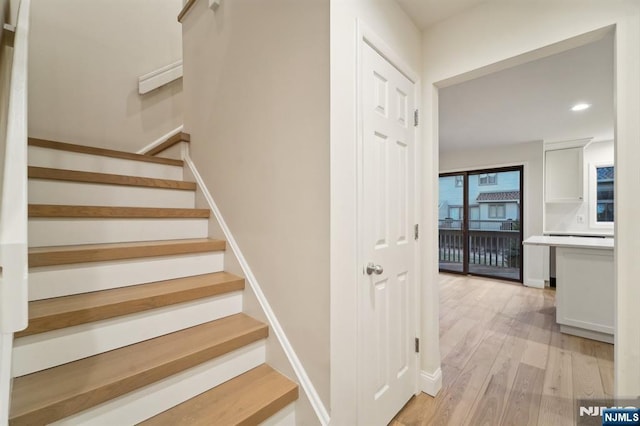 stairway featuring recessed lighting, baseboards, and wood finished floors