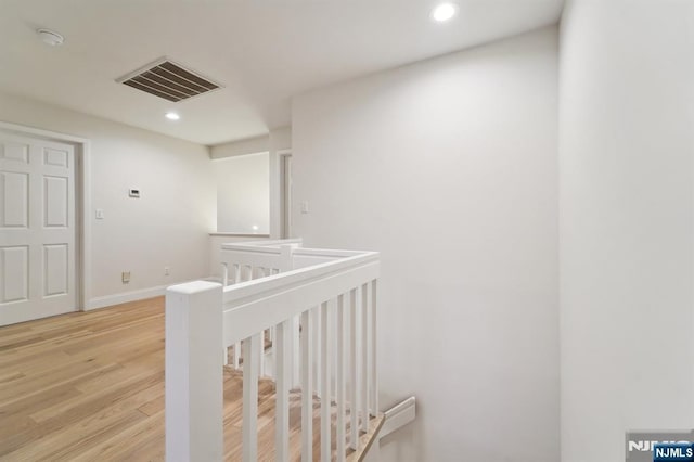 hallway featuring visible vents, baseboards, an upstairs landing, recessed lighting, and light wood-style floors