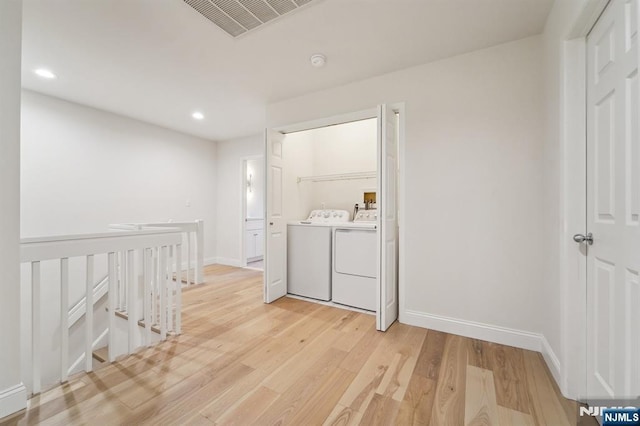 laundry room with baseboards, visible vents, light wood-type flooring, laundry area, and independent washer and dryer