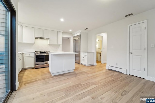 kitchen with visible vents, a kitchen island, stainless steel appliances, light countertops, and a baseboard radiator