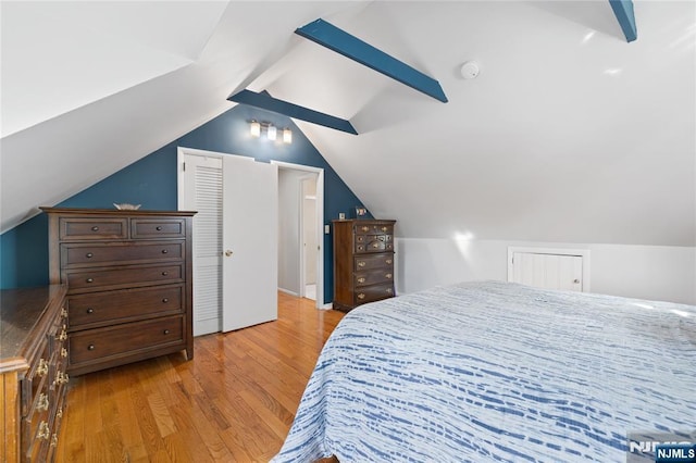 bedroom featuring lofted ceiling and light wood finished floors