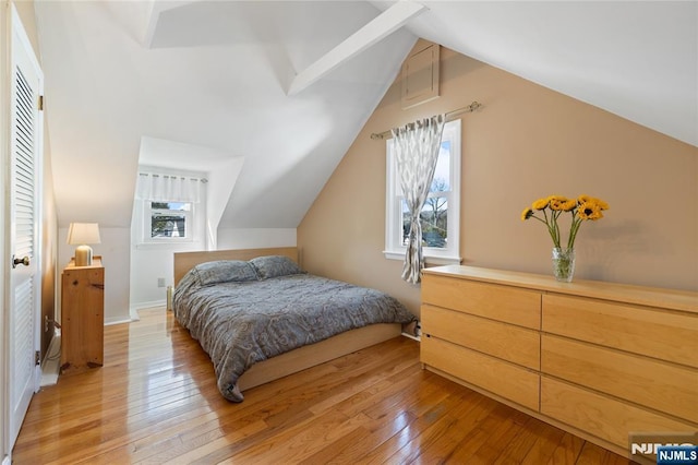 bedroom with light wood-style flooring, baseboards, and vaulted ceiling