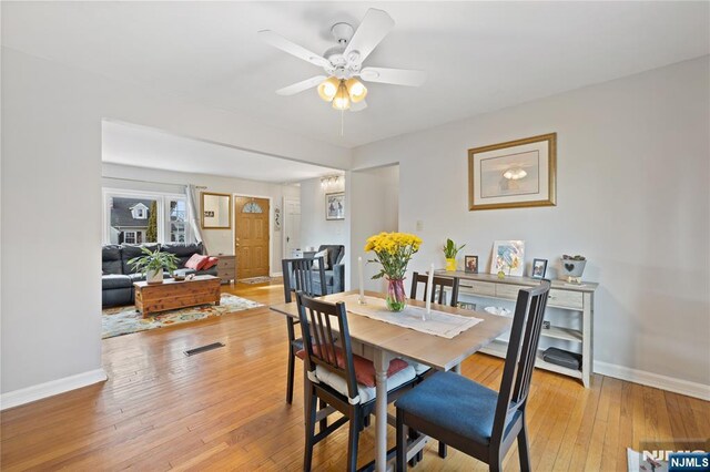 dining space featuring baseboards, light wood-type flooring, and ceiling fan